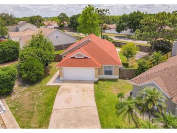 Aerial view of charming single-story home with a well-maintained lawn and a red roof at 10360 Crystal Point Dr, Orlando, FL 32825