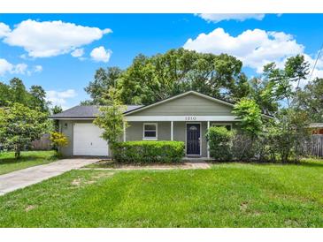 Charming one-story home with lush green lawn, mature landscaping, and a white garage door at 1210 Quintuplet Dr, Casselberry, FL 32707