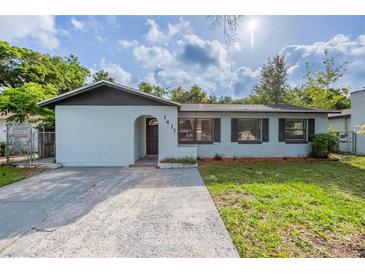 Charming single-story home with light blue paint, neat front lawn, and welcoming arched entryway at 1417 Pine Lake Rd, Orlando, FL 32808