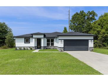 Charming one-story home featuring a two-car garage, nicely landscaped yard, and modern architectural details at 14470 Sw 46Th Ct, Ocala, FL 34473
