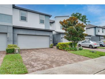 Modern townhome showcasing a two-car garage and neatly landscaped front yard on a sunny day at 1624 Little Wren Ln, Winter Park, FL 32792