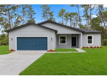 Charming single-story home with a blue garage door, well-manicured lawn, and nicely landscaped front yard at 17397 Sw 41St Cir, Ocala, FL 34473