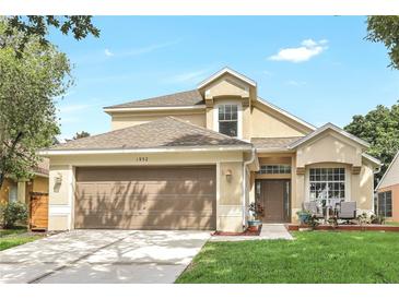 Charming two-story home featuring a well-manicured lawn, a brown garage door, and a cozy front porch area at 1932 Westpointe Cir, Orlando, FL 32835