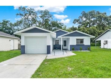 Charming single-story home featuring a well-manicured lawn and a modern two-tone color scheme at 324 James Pl, St Cloud, FL 34769