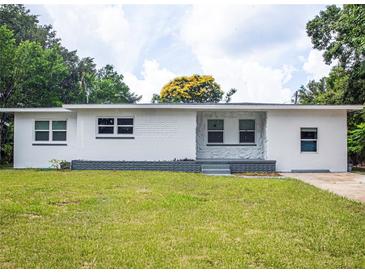 Charming single-story home featuring a freshly painted exterior, manicured lawn, and classic landscaping at 3410 Calumet Dr, Orlando, FL 32810