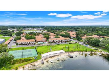 Expansive aerial view of the community, showcasing lush landscaping, water access, and recreational amenities at 5323 Hansel Ave # E14, Orlando, FL 32809