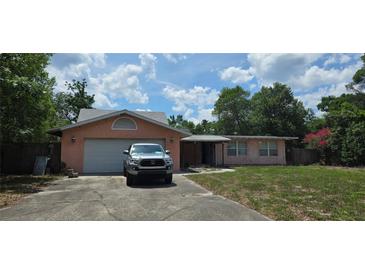 Charming single-story home featuring stucco exterior, attached garage, and mature landscaping on a sunny day at 5612 Ridgeway Dr, Orlando, FL 32819