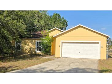 Charming single-Gathering home featuring an attached two-car garage and beautifully landscaped front yard at 607 Escondido Ct, Kissimmee, FL 34758