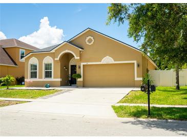 Charming single-Gathering home featuring a well-maintained lawn, two-car garage, and welcoming front entrance at 608 Washington Way, Haines City, FL 33844
