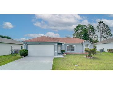 Charming single-story home with well-maintained lawn and attached two-car garage on a sunny day at 611 Jura Ln, Kissimmee, FL 34759