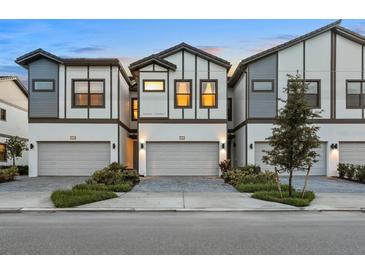 Modern townhomes featuring two-car garages, sleek design, and inviting curb appeal with manicured landscaping at 10293 Ebb Tide Ln, Orlando, FL 32821