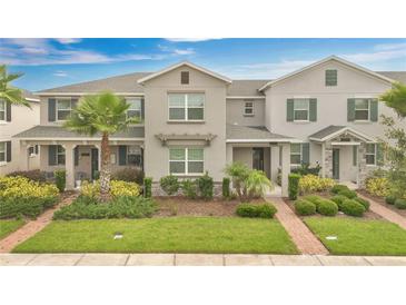 Charming townhome boasts a well-manicured lawn, lovely landscaping, and inviting facade at 12015 Prologue Ave, Orlando, FL 32832