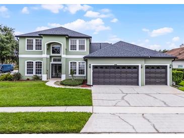 Charming two-story home featuring a three-car garage and well-manicured lawn at 201 Hammock Dunes Pl, Orlando, FL 32828