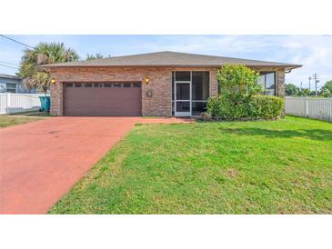 Single-story home with a brick facade, attached garage, screened entry, and well-maintained lawn at 2017 W Gore St, Orlando, FL 32805