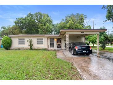 A cozy, single-story home boasts a convenient carport, neat front lawn, and inviting entrance at 2044 W Gore St, Orlando, FL 32805