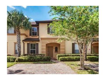 Charming two-story townhome featuring lush landscaping and a welcoming entryway at 223 Palermo St, Davenport, FL 33897