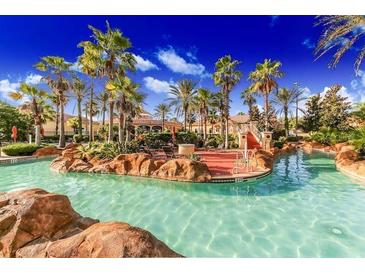 Large community pool featuring tropical landscaping and palm trees at 223 Palermo St, Davenport, FL 33897