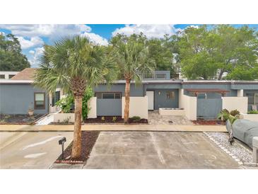 Charming single-story home with modern blue exterior, well-kept front yard, and mature palm trees at 2541 Leeward Way, Winter Park, FL 32792