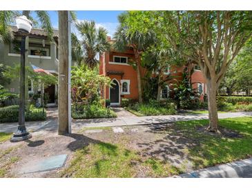 Two-story home with terracotta-colored exterior, lush landscaping, and a welcoming front walkway at 602 E Livingston St # 3, Orlando, FL 32803