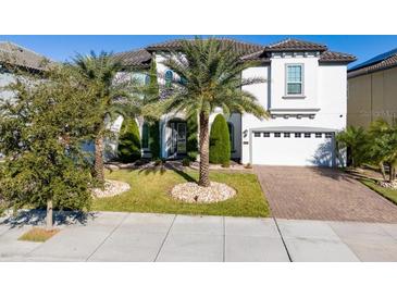 Beautiful two-story home featuring a brick driveway, manicured lawn, and a two-car garage at 8085 Ludington Cir, Orlando, FL 32836