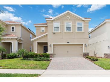 Inviting two-story home featuring a neutral color scheme, attached two car garage, and well maintained lawn at 8975 Fluffy Lie Ct, Davenport, FL 33896