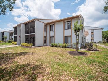 Well-maintained condo complex with two-story units, manicured landscaping, and a screened-in patio at 952 Courtyard Ln # 41, Orlando, FL 32825