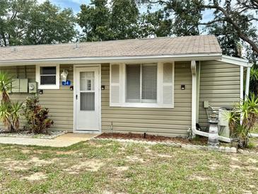 Charming single-story home featuring light green siding, a welcoming front door, and well-maintained landscaping at 10301 Us Highway 27 # 34, Clermont, FL 34711