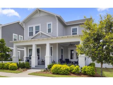 Charming two-story home with a welcoming front porch, manicured landscaping, and a light gray exterior at 1206 Civitas Way, Winter Garden, FL 34787