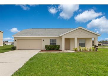 Charming single-story home featuring a well-manicured lawn and neutral-toned exterior under a bright, partly cloudy sky at 200 Cimarron Dr, Kissimmee, FL 34759