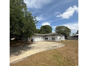 Single story home with a large driveway, well-manicured lawn, and mature trees at 337 Live Oak Blvd, Sanford, FL 32773