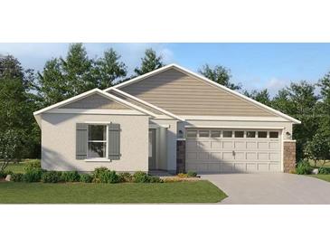 Charming single-story home showcasing a well-manicured lawn, two-car garage, and neutral color palette at 3485 Chinotto Dr, Lake Alfred, FL 33850
