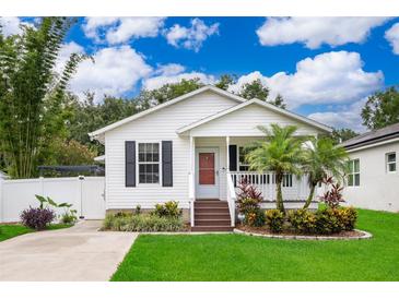Charming single-story home with a well-manicured lawn, complemented by a small front porch and landscaped garden beds at 824 Timor Ave, Orlando, FL 32804