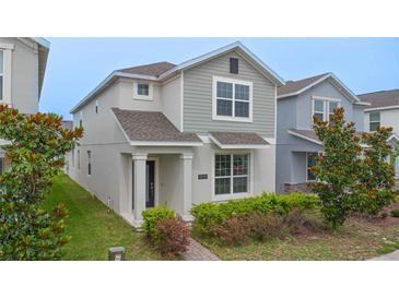 Charming two-story home featuring manicured landscaping, a welcoming entryway, and neutral color palette at 9941 Introduction Way, Orlando, FL 32832