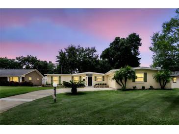 Charming single-story home with a well-manicured lawn, mature trees, and a paved driveway at 1000 Kewannee Trl, Maitland, FL 32751