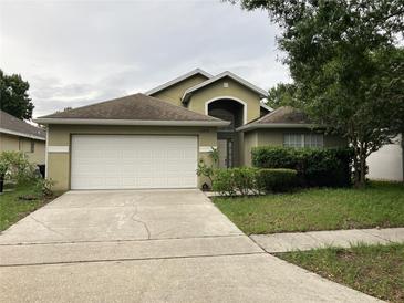 Inviting single-Gathering home featuring an attached two-car garage and well-manicured lawn at 11236 Rouse Run Cir, Orlando, FL 32817
