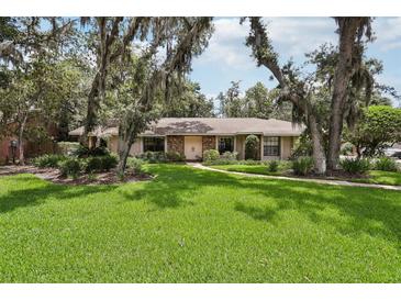 Charming single-story home with a lush green lawn and mature trees at 1425 Mt Laurel Dr, Winter Springs, FL 32708
