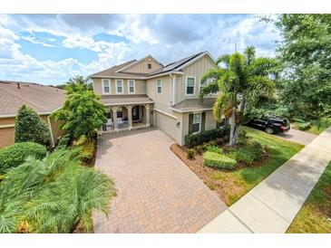 Beautiful two-story home with a well-manicured lawn, lush landscaping, and a welcoming front porch at 14744 Spotted Sandpiper Blvd, Winter Garden, FL 34787