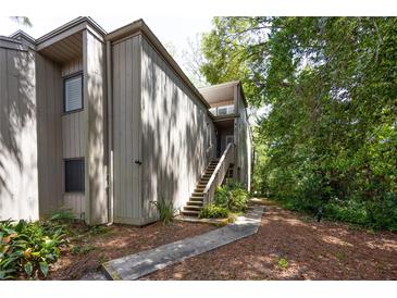 Inviting townhome featuring wood siding, stairs to the entrance and well-maintained landscaping at 211 Crown Oaks Way # 205, Longwood, FL 32779