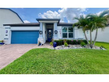 Charming single-story home with a blue garage door, stone accents, and beautifully landscaped front yard at 2390 Standing Rock Cir, Oakland, FL 34787