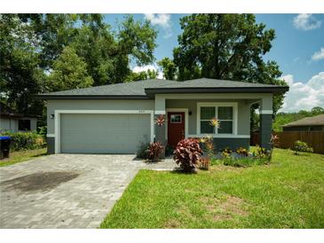 Charming single-story home features a gray exterior, brick driveway, and well-maintained landscaping at 309 E 13Th St, Apopka, FL 32703