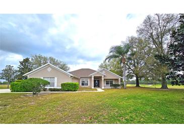 Charming single-story home with a well-manicured lawn, mature trees, and tasteful landscaping at 36730 Oconee Ave, Eustis, FL 32736