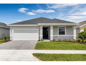 Inviting single-story home with manicured lawn, a paved driveway, and a 2-car garage at 3756 Watercliff Cir, Grand Island, FL 32735
