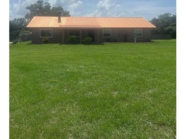 Charming single-story home featuring a lovely brick facade and a sprawling green lawn at 4160 Packard Avenue, St Cloud, FL 34772