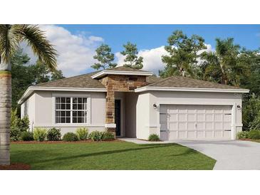 Charming single-story home featuring a stone accent wall and a well-manicured lawn surrounded by mature trees at 4741 Katrina Dr, Haines City, FL 33844