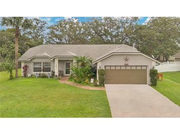 Charming single-story home with well-manicured lawn, mature trees, and welcoming front entrance, complete with a two-car garage at 4865 Gorham Ave, Orlando, FL 32817