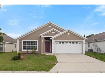 Charming single-story home with a well-maintained lawn and a two-car garage in a sunny neighborhood at 631 Lady Diana Dr, Davenport, FL 33837