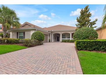Charming single-story home with a brick driveway and beautifully landscaped front yard at 7918 Esta Ln, Orlando, FL 32827