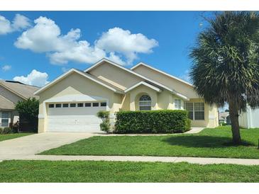 Charming single-story home with a well-manicured lawn, lush hedges, and a large palm tree providing shade at 8093 Indian Creek Blvd, Kissimmee, FL 34747