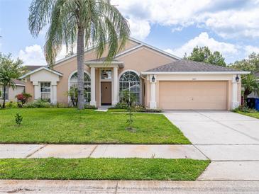Charming single-story home with a well-maintained lawn, mature landscaping, and a two-car garage at 1672 Canoe Creek Rd, Oviedo, FL 32766
