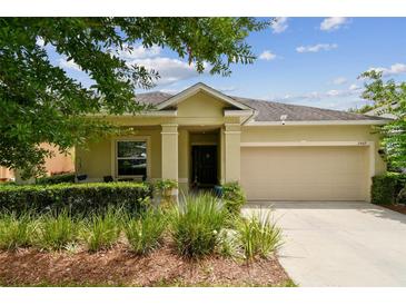 Charming one-story home featuring a two-car garage, manicured landscaping and a covered front porch at 2409 Martins Run, Tavares, FL 32778